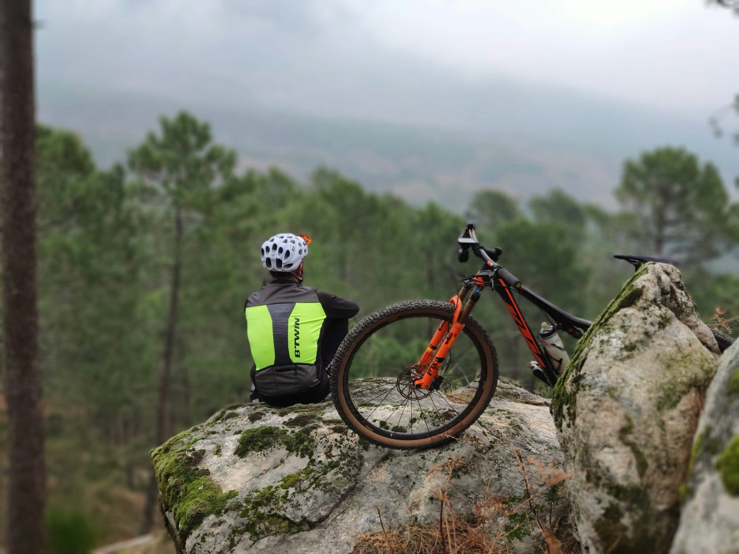 man on rock beside bicycle