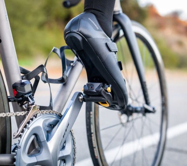 Imagem de close-up de taco de pedal de bicicleta desgastado ao lado de um novo, em um ciclista numa rua